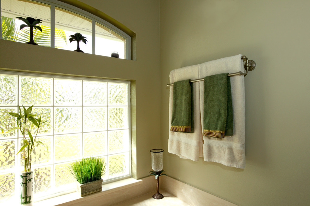 White and green towels are hung on the hangers in the bathroom
